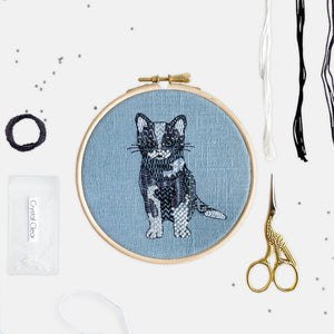 Cat Embroidery Kit - Kirsty Freeman Design. Black and white cat embroidery hoop, completed using modern embroidery stitches, onto a blue linen fabric.