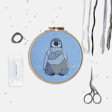 Load image into Gallery viewer, Penguin Embroidery Kit - Kirsty Freeman Design. A penguin stitched using modern, patterned embroidery stitches, created in black, white and shades of grey. The design is stitched onto blue linen fabric and has white seed bead snowflake stitched onto the background.
