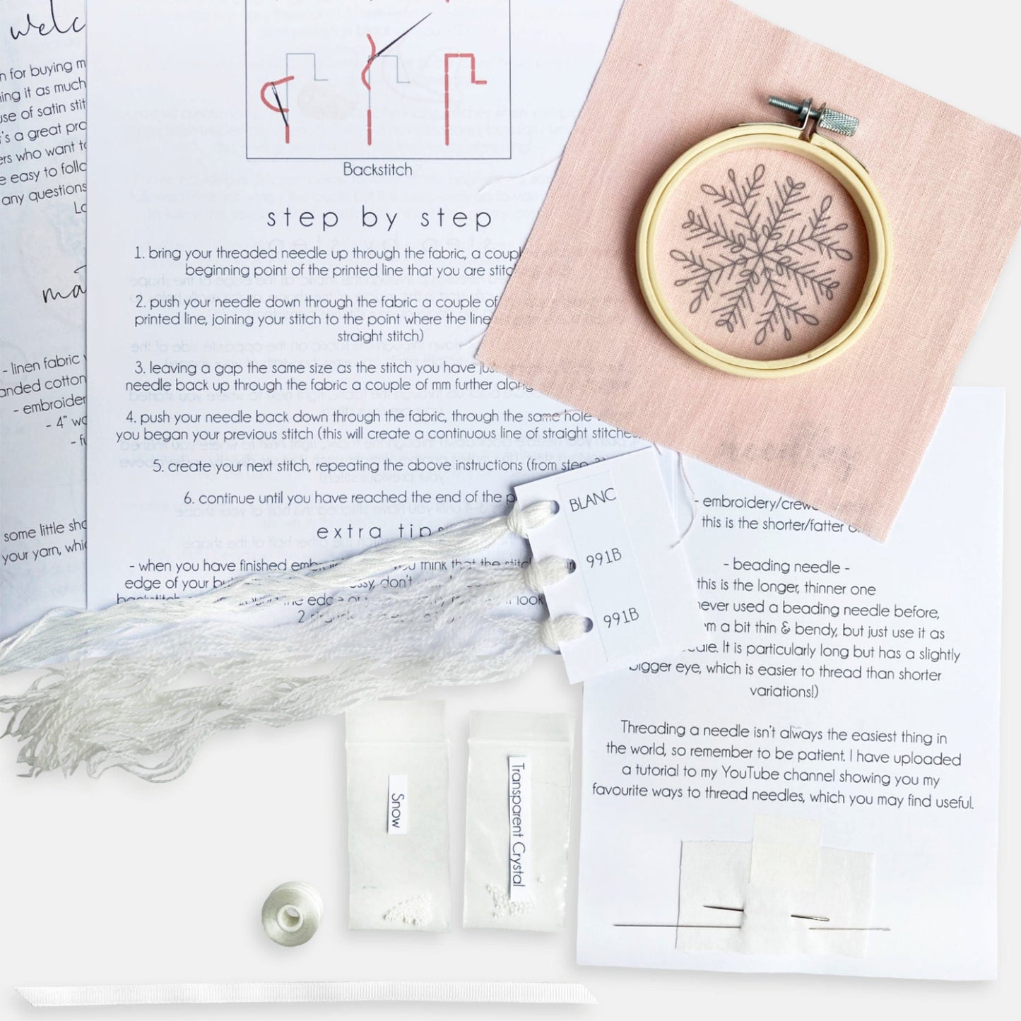 Snowflake Embroidery Kit - Kirsty Freeman Design. The contents of the embroidery kit include: instructions, pre-printed fabric, embroidery hoop, needles, threads, beads and ribbon.