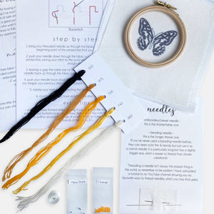 Mustard Yellow Butterfly Embroidery Kit - Kirsty Freeman Design. A close look at the contents of the craft kit: needles, beads, threads, instructions, fabric and an embroidery hoop.