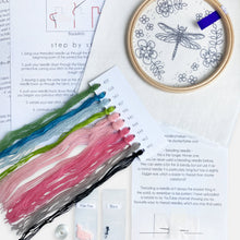 Load image into Gallery viewer, Dragonfly Embroidery Kit - Kirsty Freeman Design. A photograph of what you get inside an embroidery kit. You will receive: needles, beads, plenty of threads, instructions, an embroidery hoop and fabric with the design pre-printed - ready to start stitching.
