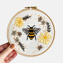 Load image into Gallery viewer, Bee Embroidery Kit - Kirsty Freeman Design. A close look at the finished kit, created using shads of orange, yellow and beige, on a white linen fabric background and presented inside an Elbesee embroidery hoop.
