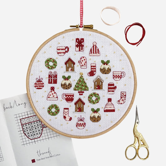 Advent Calendar Cross Stitch Kit – finished festive hoop surrounded by embroidery threads, scissors and instructions.