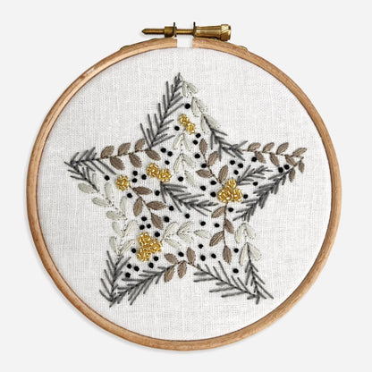 Close-up of completed Christmas Star Embroidery Kit showing botanical leaves, berries and gold seed beads in a star motif.