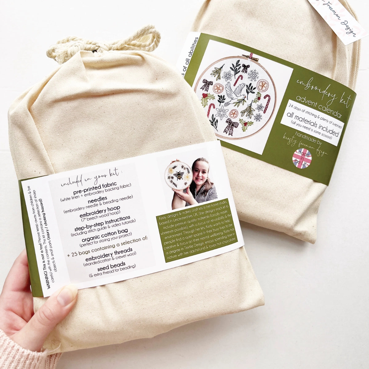 Back of Advent Calendar Embroidery Kit packaging showing band with product information and blurb about the maker, wrapped around cotton bag.