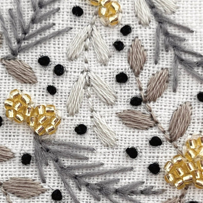 Close-up view of Christmas Star Embroidery Kit details created with muted thread colours and gold bead clusters.