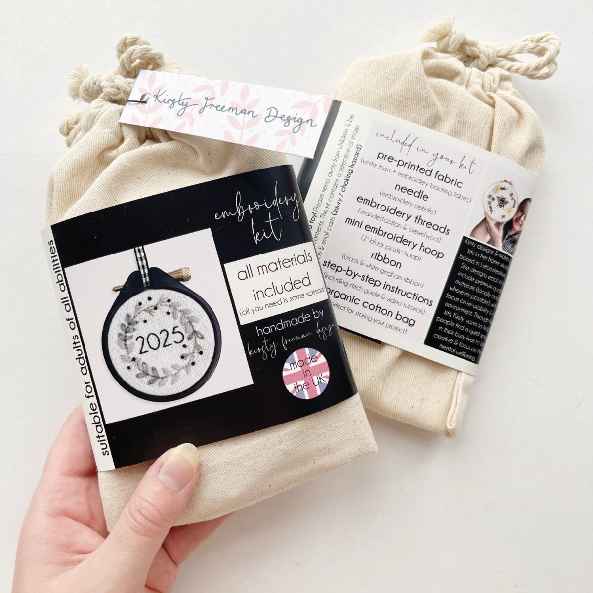 Front of Mini Christmas Wreath Embroidery Kit 2025 packaging showing monochrome wreath design and festive branding in cotton drawstring bag.