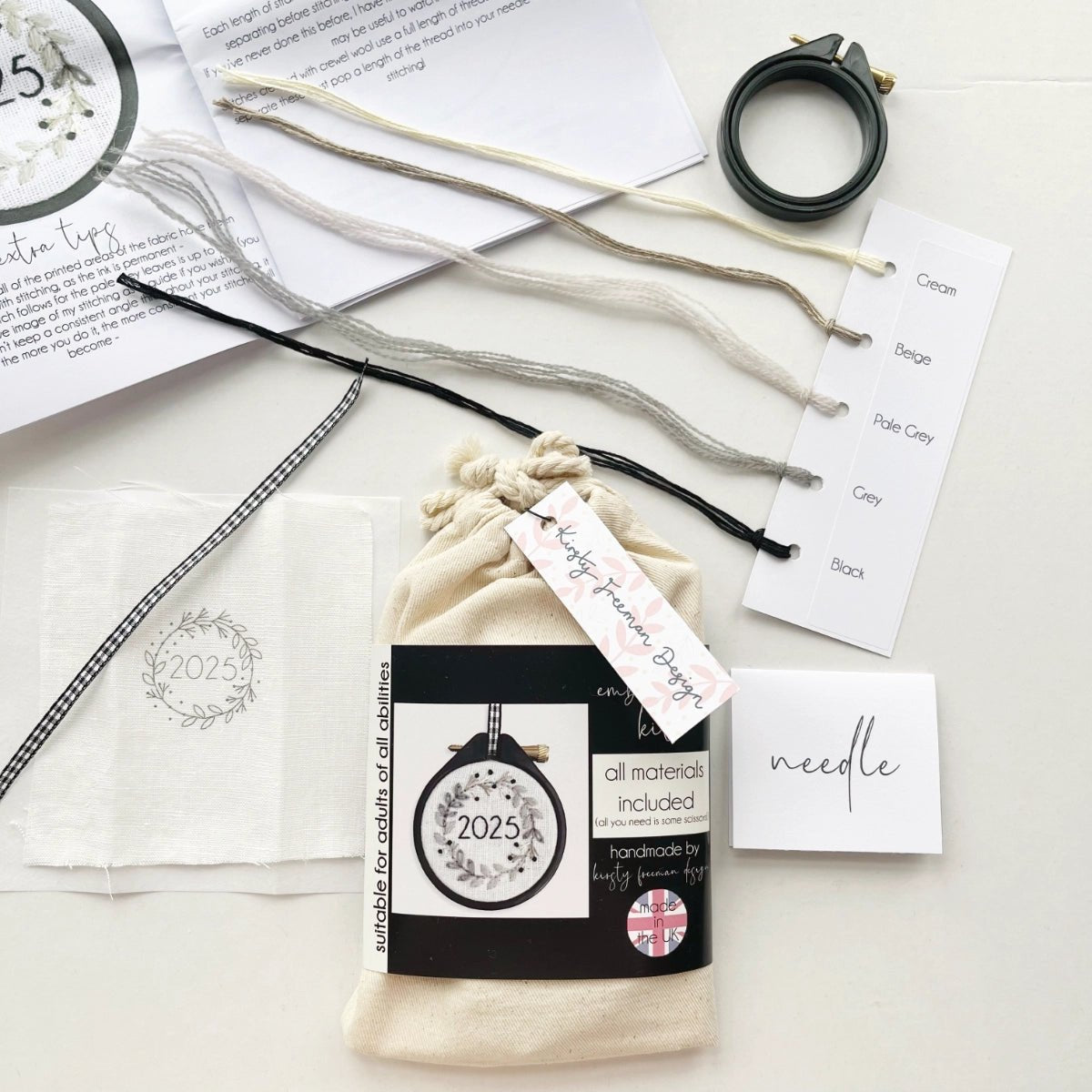 Mini Christmas Embroidery Kit 2025 packaging with fabric, hoop, threads, needle and instructions to create monochromatic wreath design.