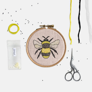 Bee Embroidery Kit Designed and Made in the UK - Kirsty Freeman Design. Patterned stitches fill a bumble bee shape in yellow, black and white threads onto a pink linen fabric.