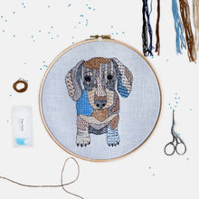 Load image into Gallery viewer, Sausage Dog Embroidery Kit - Kirsty Freeman Design. A dachshund stitched onto blue linen fabric, using patterned embroidery stitches and seed beads.
