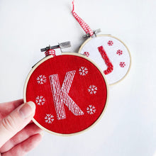 Load image into Gallery viewer, Christmas Letter Embroidery Kit - Kirsty Freeman Design. Simple embroidery decoration of letter K, stitched onto red linen, using white embroidery thread.
