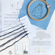 Load image into Gallery viewer, Penguin Embroidery Kit - Kirsty Freeman Design. The contents included: fabric with pre-stitched outline, embroidery hoop, instructions, needles, threads and beads.
