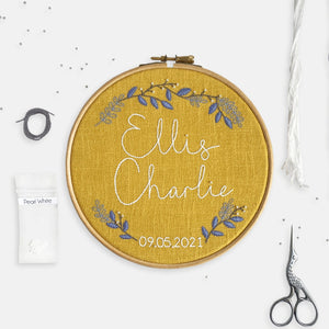 Baby Embroidery Kit - Kirsty Freeman Design. A mustard yellow personalised embroidery kit design, with the name of a new baby stitched across the centre of the hoop in white DMC stranded cotton.