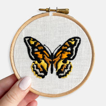 Load image into Gallery viewer, Butterfly Embroidery Kit - Kirsty Freeman Design. The butterfly embroidery has been completed in shades of orange and black, onto a white linen background and presented inside an embroidery hoop frame.
