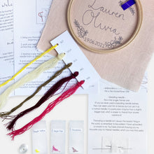 Load image into Gallery viewer, New Baby Embroidery Kit - Kirsty Freeman Design. The contents of the pink personalised kit, including a selection of threads and seed beads in shades of pink, burgundy, khaki and yellow.
