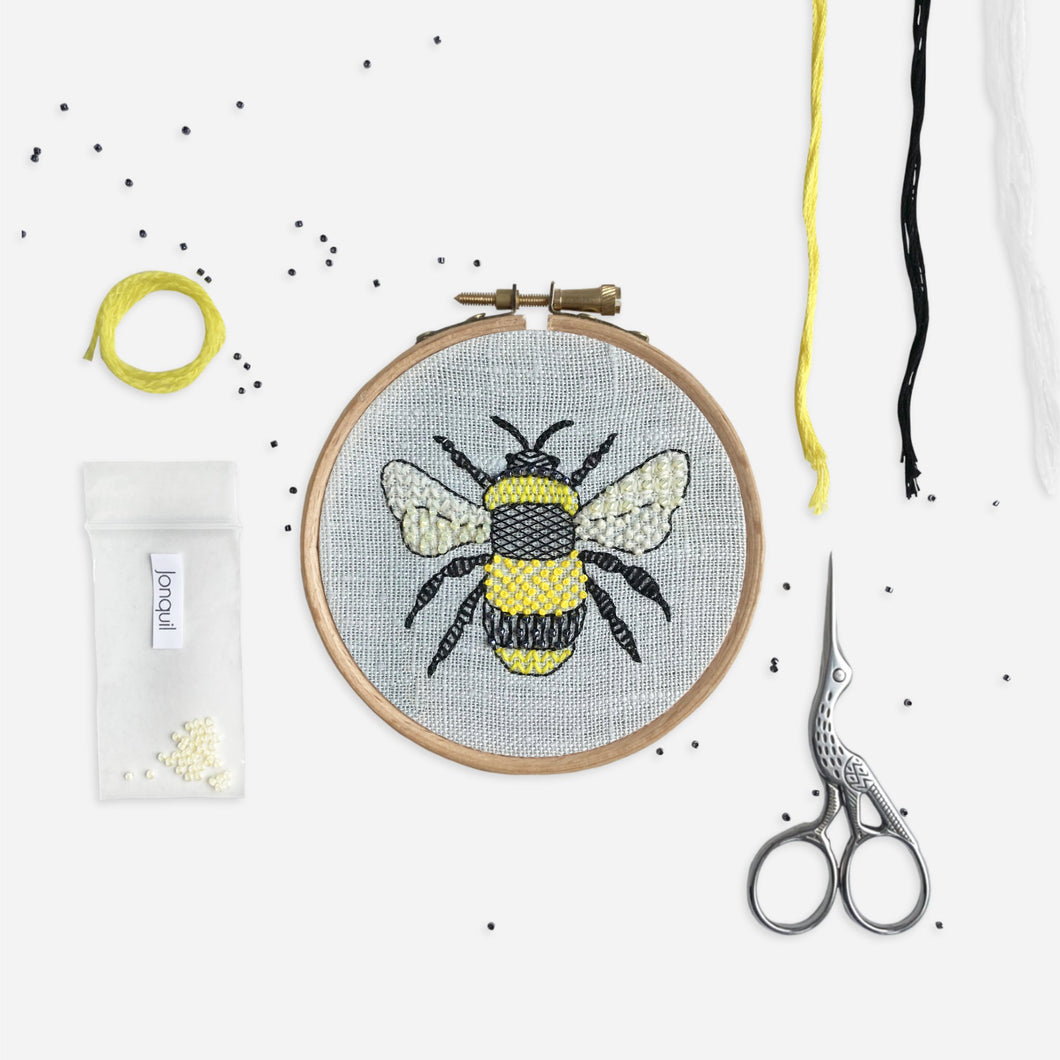 Bee Embroidery Kit Designed and Made in the UK - Kirsty Freeman Design. Bumble bee embroidered onto blue linen fabric using modern embroidery stitches.